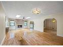 Spacious living room with a stone fireplace, hardwood floors, skylights, and a ceiling fan at 3595 Limberlost Sw Trl, Stockbridge, GA 30281