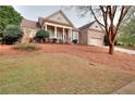 Charming brick home featuring a covered porch with classic columns and landscaped front yard at 2570 Middleton Way, Grayson, GA 30017