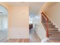 Open foyer featuring hardwood floors, wainscoting, and a staircase with a wood banister at 3019 Iona Ct, Snellville, GA 30039