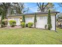Charming ranch home with a well-manicured lawn, beautiful landscaping, and a welcoming yellow front door at 2999 San Juan Dr, Decatur, GA 30032