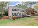 Well-maintained two-story home showcasing the manicured lawn and mature tree at 1196 Oak Sw Rd, Lilburn, GA 30047