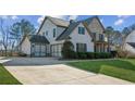 Beautiful home exterior featuring a three-car garage and large driveway at 5705 Windjammer Pt, Cumming, GA 30041