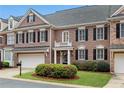 Charming brick townhome featuring an attached garage, black shutters, and manicured landscaping in a desirable community at 611 Vinings Estates Se Dr, Smyrna, GA 30126