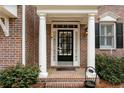 Charming brick home featuring a classic black front door with white columns and manicured landscaping at 611 Vinings Estates Se Dr, Smyrna, GA 30126