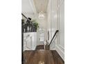 Elegant foyer with high ceilings, paneled walls, and hardwood flooring, leading to a staircase at 9044 Riverbend Manor, Alpharetta, GA 30022