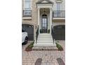 Elegant front entrance with a black door, white pillars, and a brick-paved driveway at 9044 Riverbend Manor, Alpharetta, GA 30022