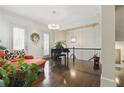 Bright living room with hardwood floors, a black piano, an orange sofa, and staircase views at 9044 Riverbend Manor, Alpharetta, GA 30022