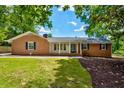 Traditional brick home featuring a covered porch and manicured front lawn at 1840 Linwood Ave, Atlanta, GA 30344