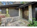 Close up of the front entrance featuring stone columns and a stone wall with wood and glass doors at 2568 Sugarplum Ne Ct, Atlanta, GA 30345