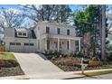 Elegant two-story white home with a covered porch, beautiful landscaping, and a spacious two-car garage at 52 25Th Nw St, Atlanta, GA 30309