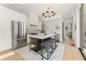 Modern kitchen featuring stainless steel appliances, marble countertops, and an island with seating at 10940 Serenbe Ln, Chattahoochee Hills, GA 30268