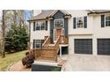 Welcoming front entrance with wooden stairs, a two-car garage and a neatly kept lawn at 7170 Highbrook E Cir, Cumming, GA 30041