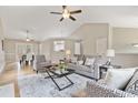 Spacious living room featuring hardwood floors, vaulted ceilings, and elegant decor, with a view into the dining room at 7170 Highbrook E Cir, Cumming, GA 30041