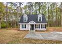 Inviting two-story home with a well-maintained lawn, black shutters, and dormer windows at 214 Walton St, Loganville, GA 30052