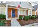 Inviting brick entryway with an American flag, blue door adorned with a wreath, and manicured bushes at 2368 Barrett Cottage # 17, Marietta, GA 30066