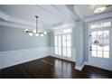 Dining room with dark wood floors, modern light fixture, and bright white trim at 5712 Kendrick Ln, Cumming, GA 30041