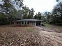 Quaint brick ranch home featuring black shutters, a covered carport, and a yard full of leaves at 2369 Christian Cir, Covington, GA 30016