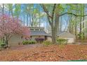 Charming one-story home with mature trees, blooming bushes, and an attached two-car garage at 3696 Suwanee Creek Ct, Suwanee, GA 30024