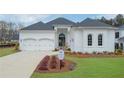 Beautiful white brick home with a well-manicured lawn, three-car garage, and a welcoming front entrance at 103 Candler Loop, Acworth, GA 30101