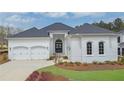 Beautiful white brick home with a manicured lawn, arched windows, a two-car garage and a dark, arched front door at 103 Candler Loop, Acworth, GA 30101