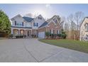 Attractive two-story home boasts a brick and siding exterior, attached garage, and manicured lawn at 917 Redstone Trl, Dacula, GA 30019