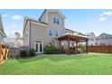Well-maintained backyard with green grass, a wooden pergola, and privacy fence, perfect for outdoor enjoyment at 11395 Crestview Ter, Johns Creek, GA 30024