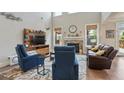 Open living room with high ceilings, hardwood floors, a stone fireplace, and large windows for natural light at 11395 Crestview Ter, Johns Creek, GA 30024