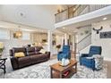 Open-concept living area with hardwood floors, a staircase, and views into the kitchen and dining areas at 11395 Crestview Ter, Johns Creek, GA 30024