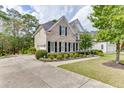 Beautiful home exterior featuring lush landscaping, a long driveway, and classic architectural details at 1718 Autumn Sage Dr, Dacula, GA 30019