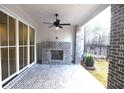 Relaxing covered patio features a ceiling fan and an outdoor fireplace at 502 Clover Ln, Alpharetta, GA 30009