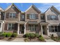 Attractive townhome exterior showcasing a brick facade with wooden shutters and a manicured front yard at 1671 Hammock Dr, Smyrna, GA 30080