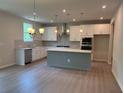 Spacious kitchen featuring stainless steel appliances, ample lighting, and a gray kitchen island at 363 Riverwood Pass, Dallas, GA 30157