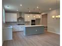 Open kitchen with white cabinetry, stainless steel appliances, and a gray kitchen island at 363 Riverwood Pass, Dallas, GA 30157
