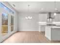 Bright dining area features a modern chandelier, wood floors, and a large window with views at 373 Riverwood Pass, Dallas, GA 30157