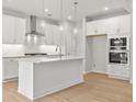 This modern kitchen features stainless steel appliances, a center island with a sink, and white cabinets at 373 Riverwood Pass, Dallas, GA 30157