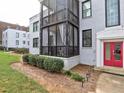Multi-level condo with screened porch area, manicured landscaping, and red front door at 88 Peachtree Memorial Nw Dr # 88, Atlanta, GA 30309