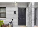 A dark front door of unit 6 in front of a white brick exterior wall at 1683 Briarcliff Rd # 6, Atlanta, GA 30306