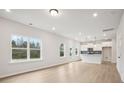 Open-concept living space showcases large windows and flows seamlessly into the modern kitchen at 27 Kensington St, Kingston, GA 30145