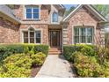 Charming brick home with manicured landscaping and welcoming entrance, exuding curb appeal at 6935 York Pl, Cumming, GA 30040