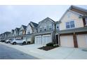 Street view showcasing multiple townhomes, each with garages and varied siding colors at 1905 Granville Dr, Lawrenceville, GA 30043