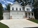 Beautiful two-story home featuring white siding, brick accents, and a spacious three-car garage at 30 Riverrock Trl, Dallas, GA 30157