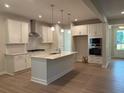 Spacious kitchen with white cabinets, stainless steel appliances, and a large center island at 30 Riverrock Trl, Dallas, GA 30157