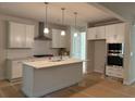 Bright kitchen featuring white cabinets, stainless steel appliances, and a center island with quartz countertop at 30 Riverrock Trl, Dallas, GA 30157