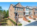 Attractive brick townhome featuring a well-manicured lawn, attached garage, and classic architectural details at 4852 Merriman Se Walk # 23, Atlanta, GA 30339