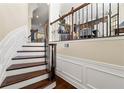 Elegant staircase with hardwood steps, decorative iron railing, and classic white trim details at 4852 Merriman Se Walk # 23, Atlanta, GA 30339