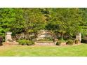 Stone entrance sign surrounded by lush landscaping welcomes you to the Wildwood community at 13912 Homer, Covington, GA 30014