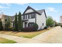 A view of the 2-story home showing landscaped yard with black mulch and concrete driveway at 1784 Hollingsworth Nw Blvd, Atlanta, GA 30318