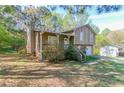 A charming home boasts a welcoming front porch and mature trees surrounding the property at 2619 Del Ridge Dr, Douglasville, GA 30135