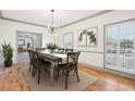 Bright dining room featuring hardwood floors, stylish chandelier, and large shuttered windows at 8671 Lake Forrest Dr, Douglasville, GA 30134
