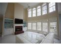Spacious living room with fireplace, soaring windows providing lots of natural light, and tile flooring at 1191 Crofton Landing, Suwanee, GA 30024